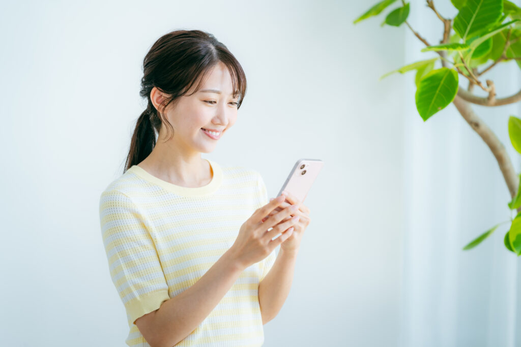 スマートフォンでスタジオの予約ページを確認する女性