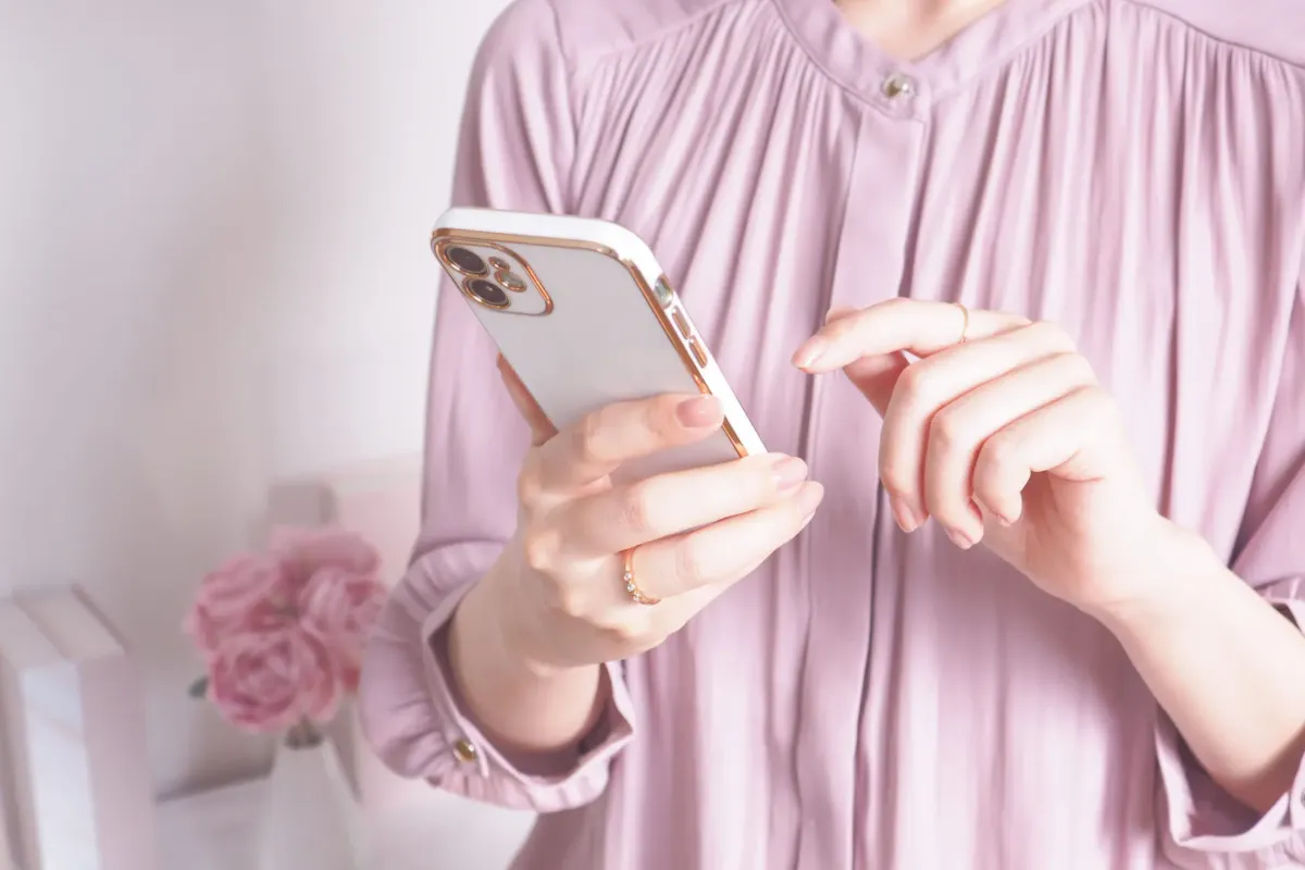 スマートフォンで広告から予約ページを見る様子